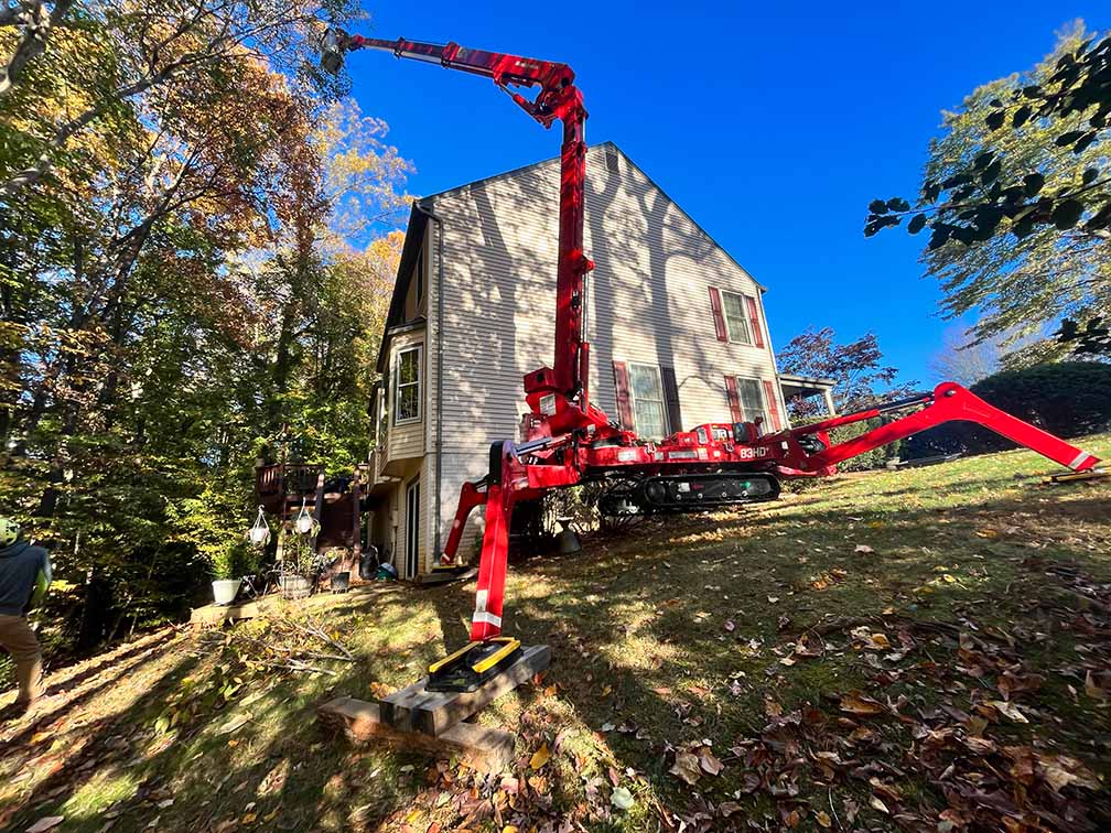 Spider lift on a hill behind a house